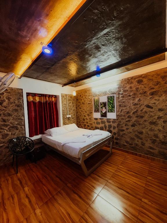 a bedroom with a bed in a room with wooden floors at SpiceBuds FarmStay - Ramakkalmedu in Idukki
