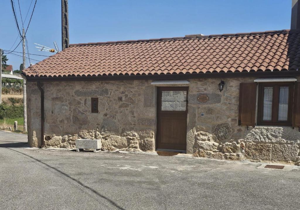 a stone building with a door and a red roof at El Lagar de Mailusa in Sayar