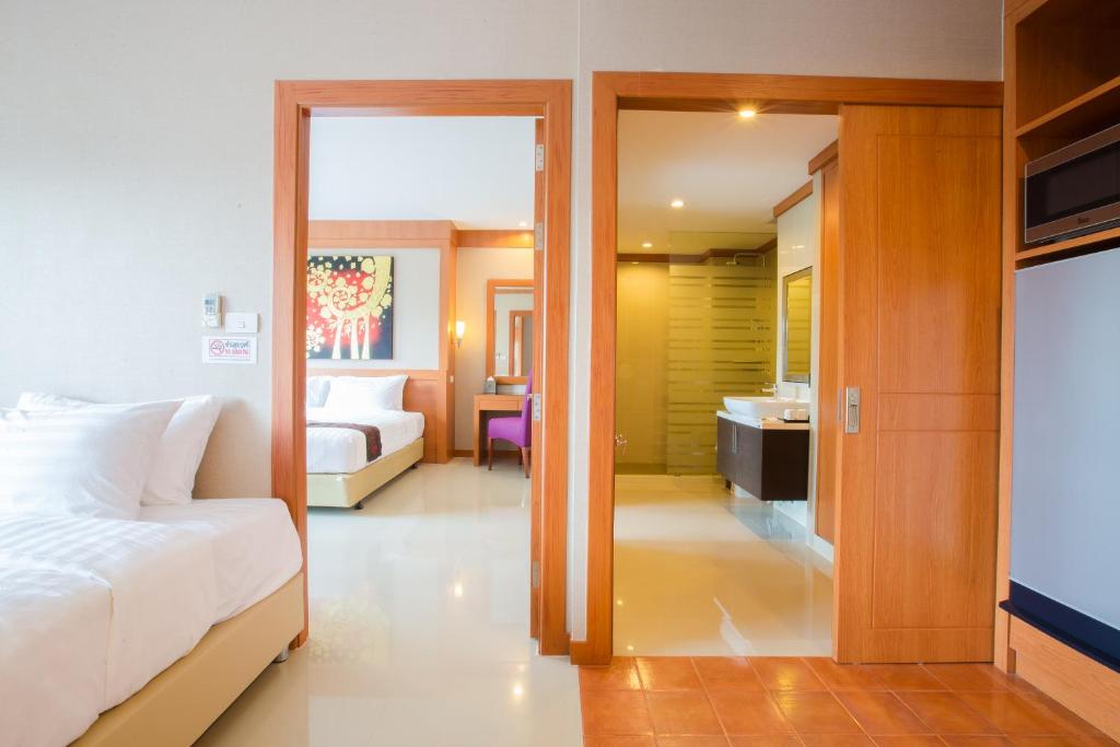 Postel nebo postele na pokoji v ubytování Romantic Khon Kaen Hotel