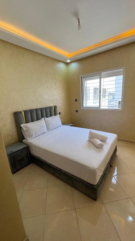 a large bed in a room with a window at Appartement Agadir in Inezgane