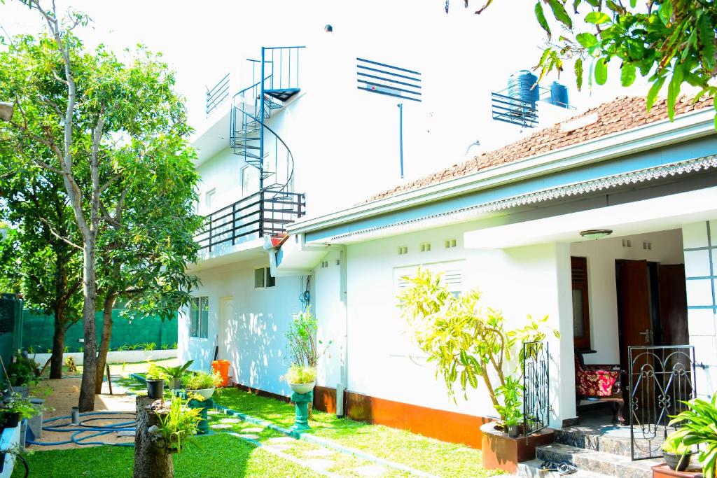 a white house with a garden in front of it at Mama Beach Villa in Negombo