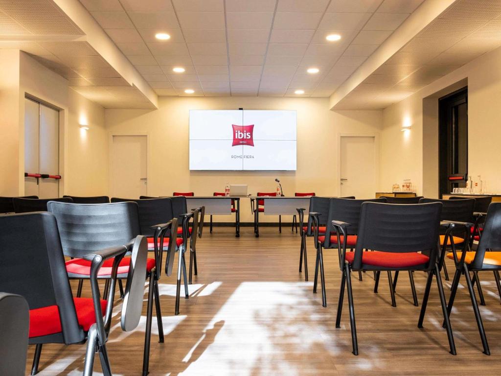 a conference room with chairs and a projection screen at Ibis Roma Fiera in Rome