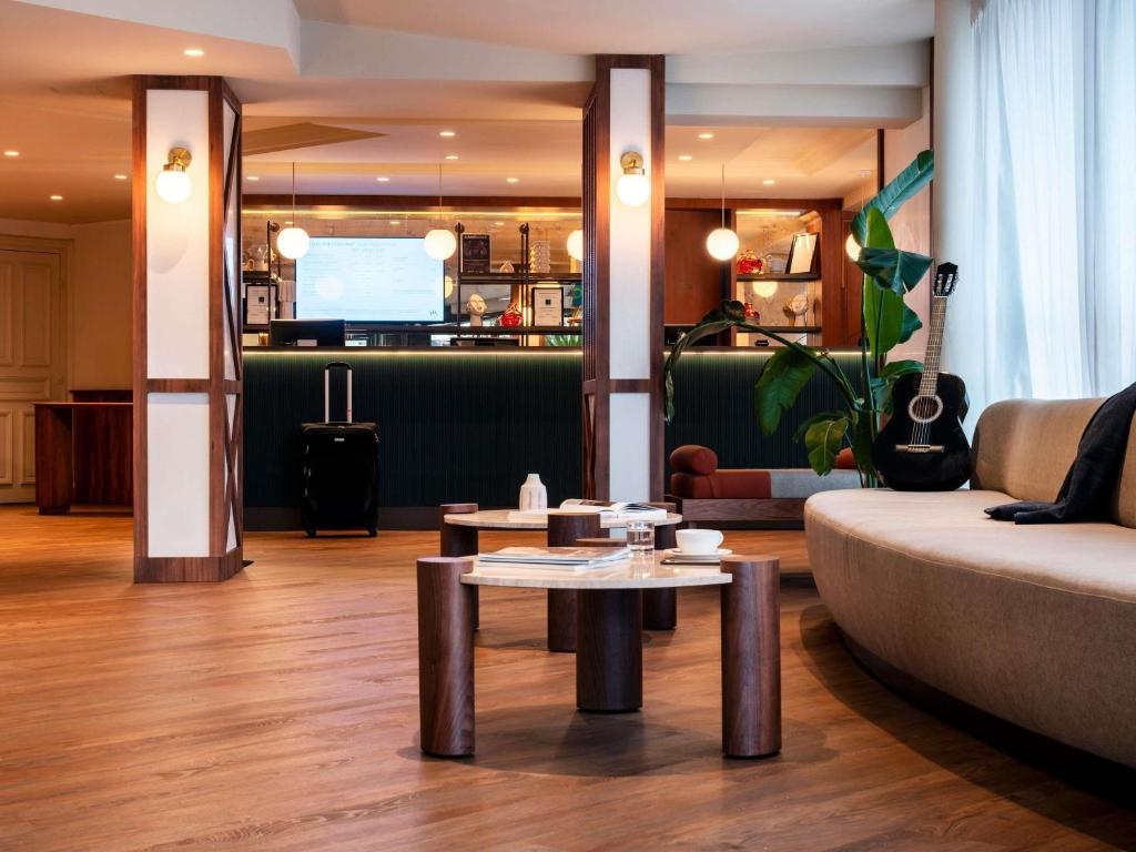 a living room with a couch and a table at ibis Rouen Centre Champ de Mars in Rouen