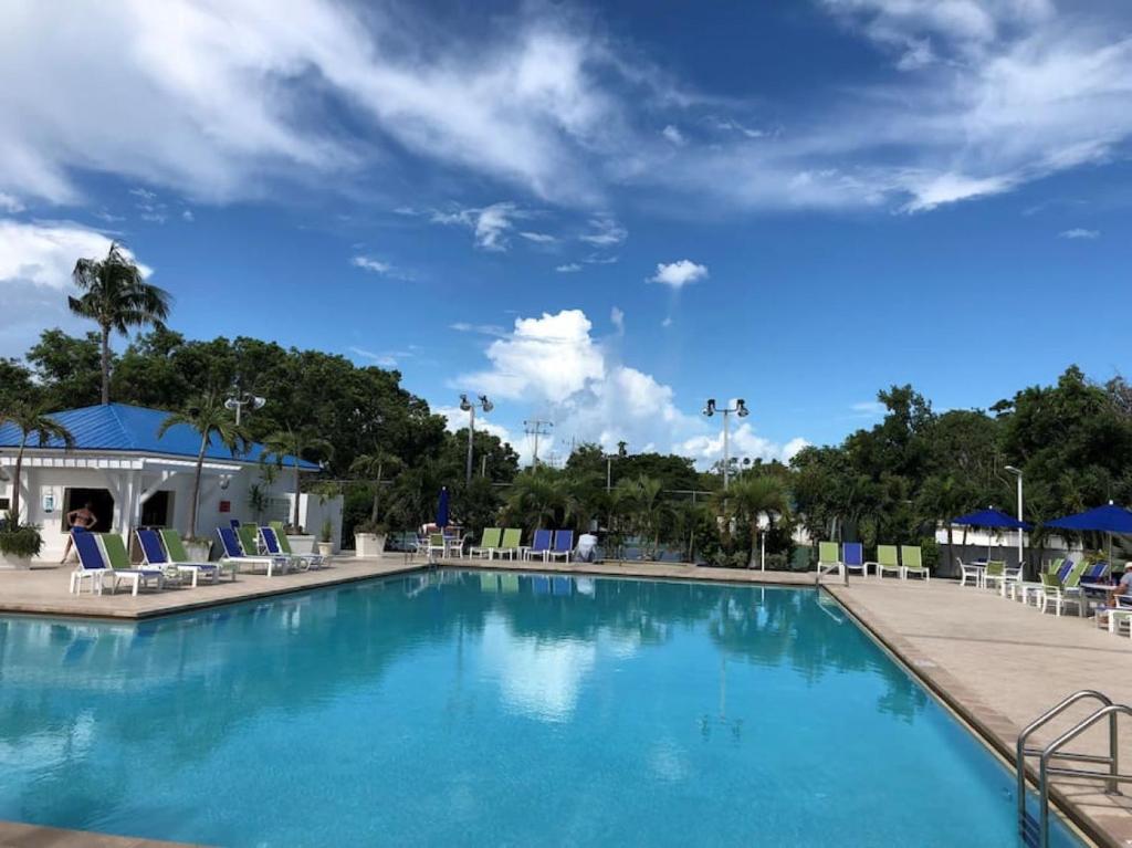 a pool at a resort with chairs and a blue sky at Ocean Pointe Resorts - Serenity 2308 in Tavernier