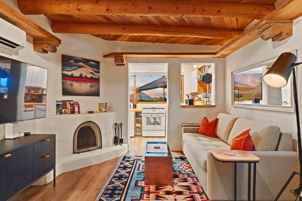 a living room with a couch and a fireplace at Restored Adobe Casita Big Views Walk to Plaza in Santa Fe