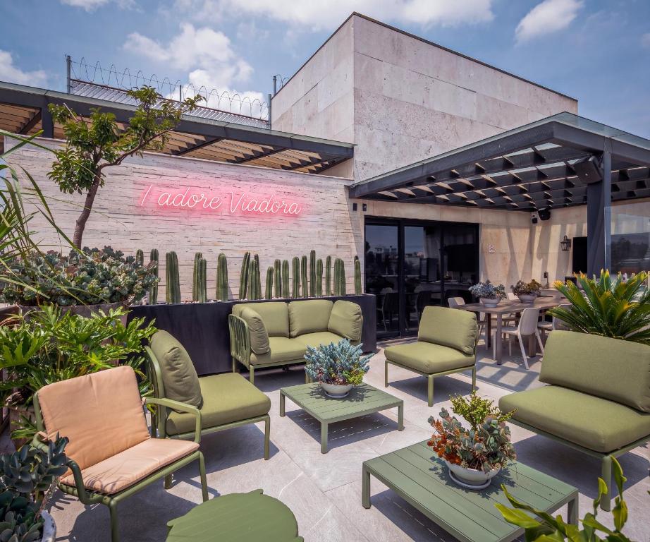 a patio with chairs and tables in front of a restaurant at Frida by Viadora in Mexico City