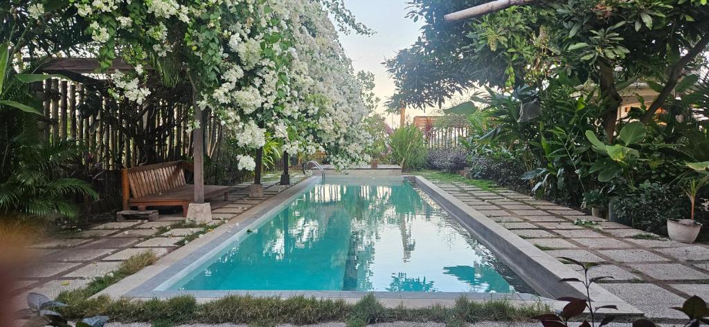 a swimming pool in the middle of a garden at Mantra Yoga Homestay in Tanjung
