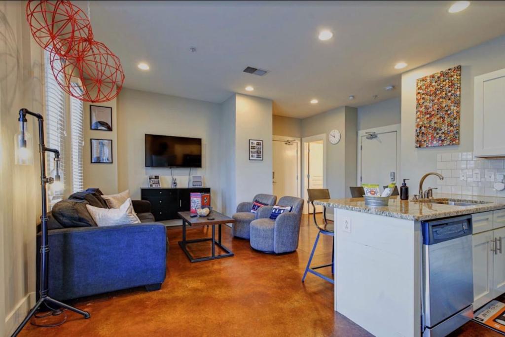 a kitchen and living room with a couch and a counter at Music Row Luxury Suites - Two King Bedrooms - Private Garage & Ensuite Baths in Nashville