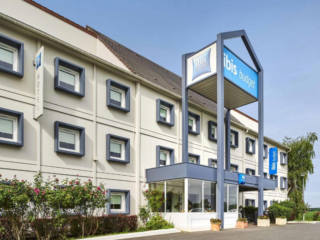 a hotel with a sign in front of a building at ibis budget Santeny in Santeny