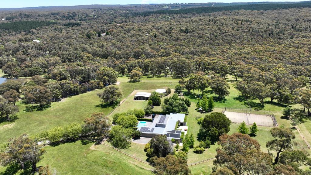 an aerial view of a house on a field with trees at Thule Country Estate - Private Architect-Designed Farm Estate, 6 Bedrooms, Sleeps 12 in Mount Macedon
