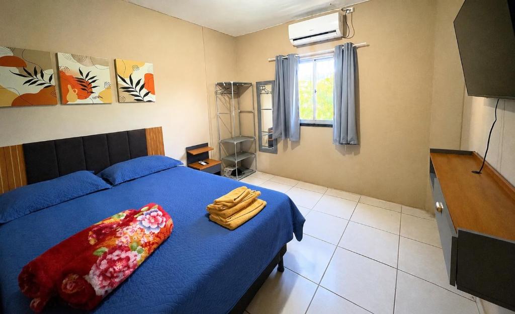 a bedroom with a bed with blue sheets and a window at Apartamento completo e central! CASA DUNAS! in Fortaleza