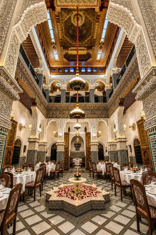 a dining room with tables and chairs and a ceiling at Riad Fes Palais Bab Sahra Suites & Cooking Workshops in Fez