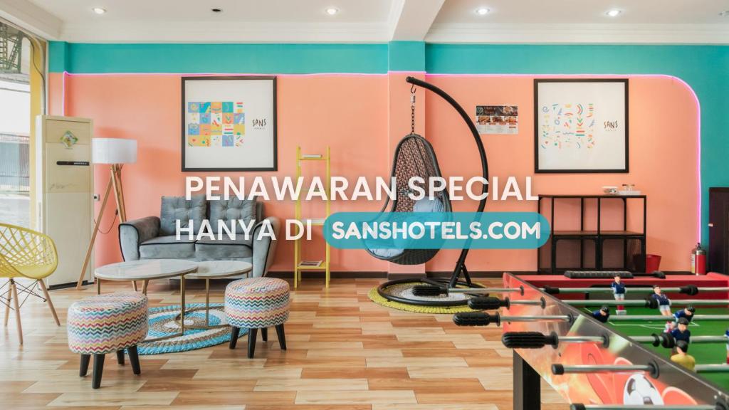a room with a ping pong table and chairs at Sans Hotel Beauty Palembang in Sukarami