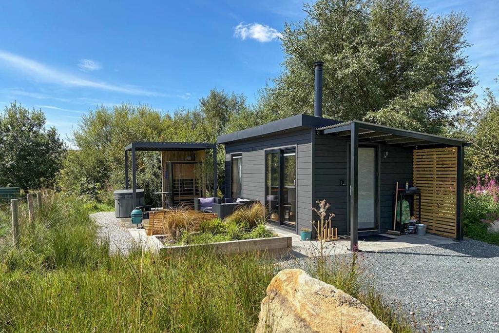 a black tiny house in a garden with trees at 1 Bed in Austwick oc-b37509 in Austwick