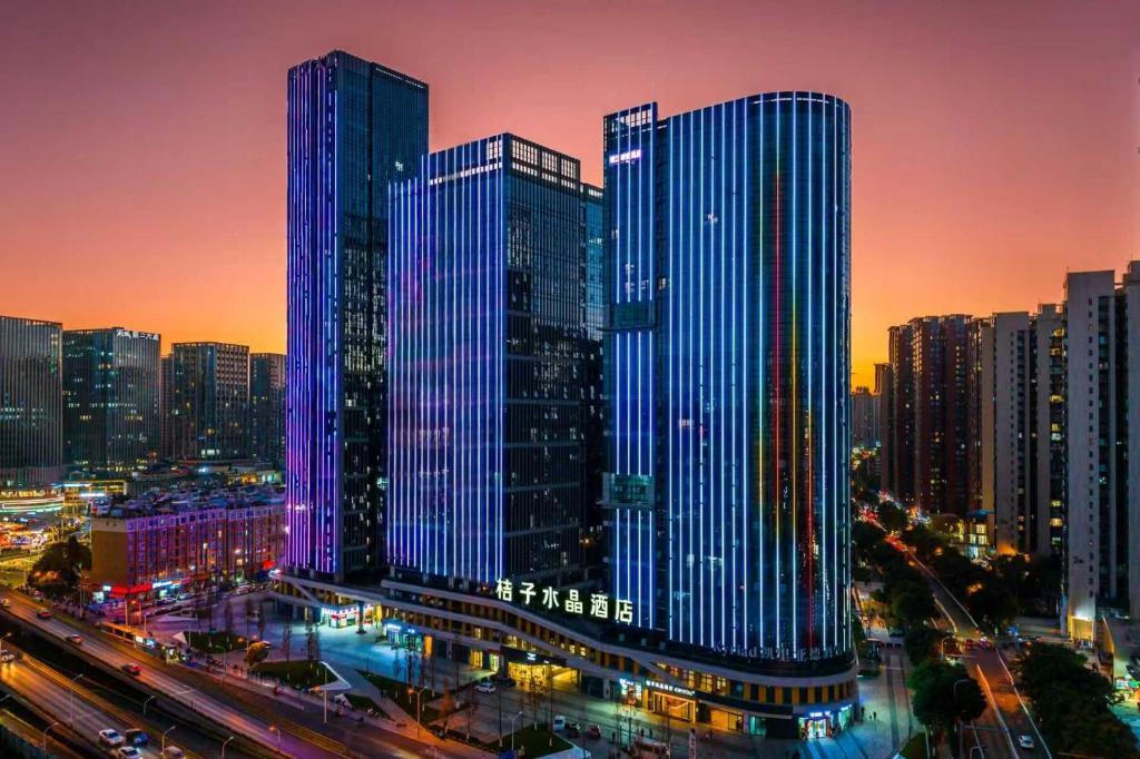 a group of tall buildings in a city at night at Orange Crystal Hotel Kunming Wanda Plaza in Kunming