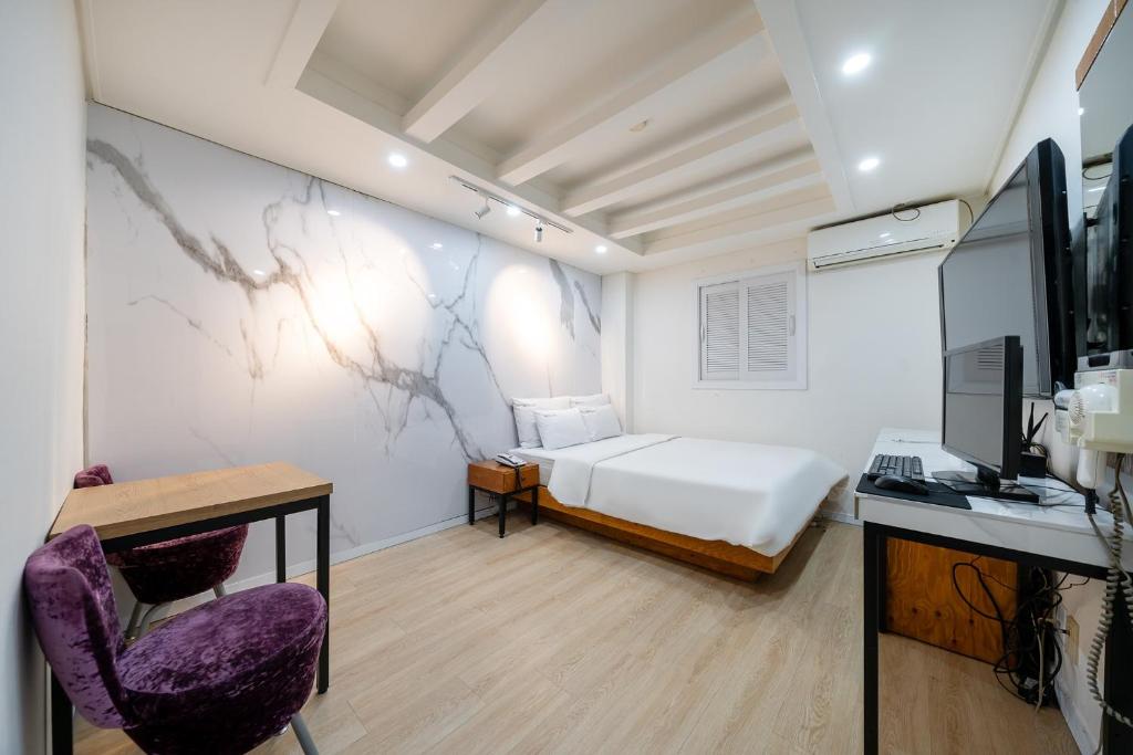 a bedroom with a bed and a desk and a tv at Yeon Stay in Seoul