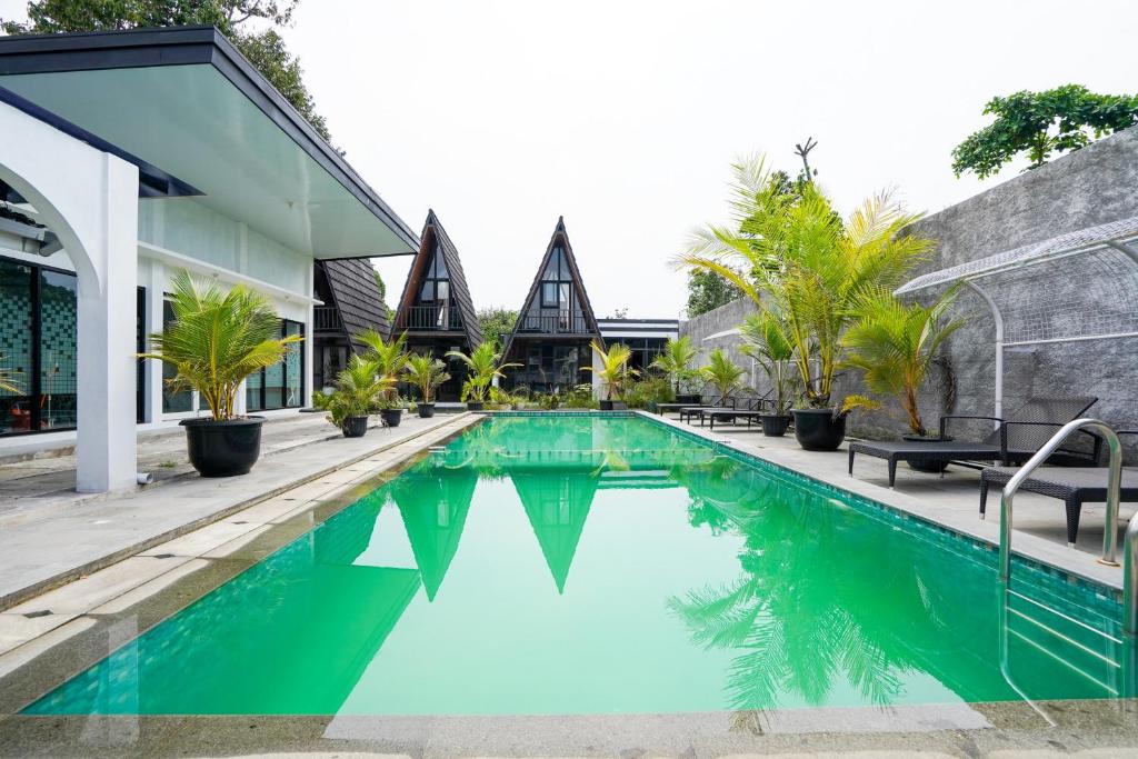 a swimming pool in front of a building with a house at The Lavana Astungkara in Beran-kidul