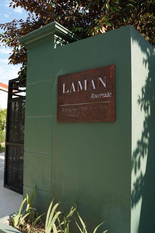 a sign on the side of a green wall at Laman Riverside in Nguyên Ngoại