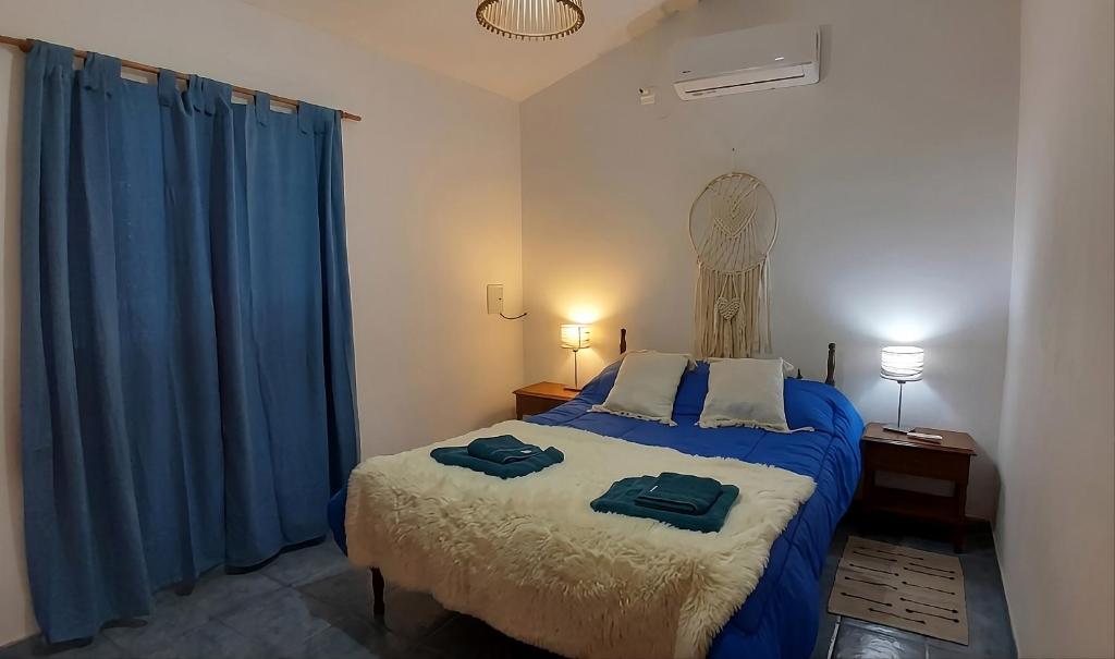 a bedroom with a bed with two towels on it at Home Talampaya in Villa Unión