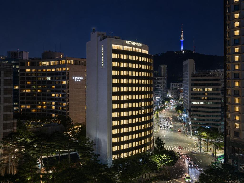 a lit up building in a city at night at UH Continental SeoulCenter in Seoul