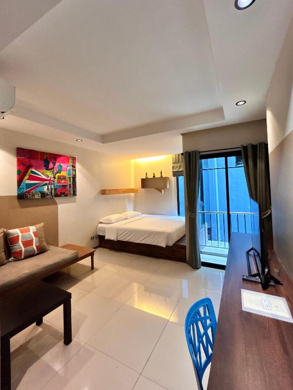 a hotel room with a bed and a couch at Varrzon Residence Srinakarin 56 in Bangna