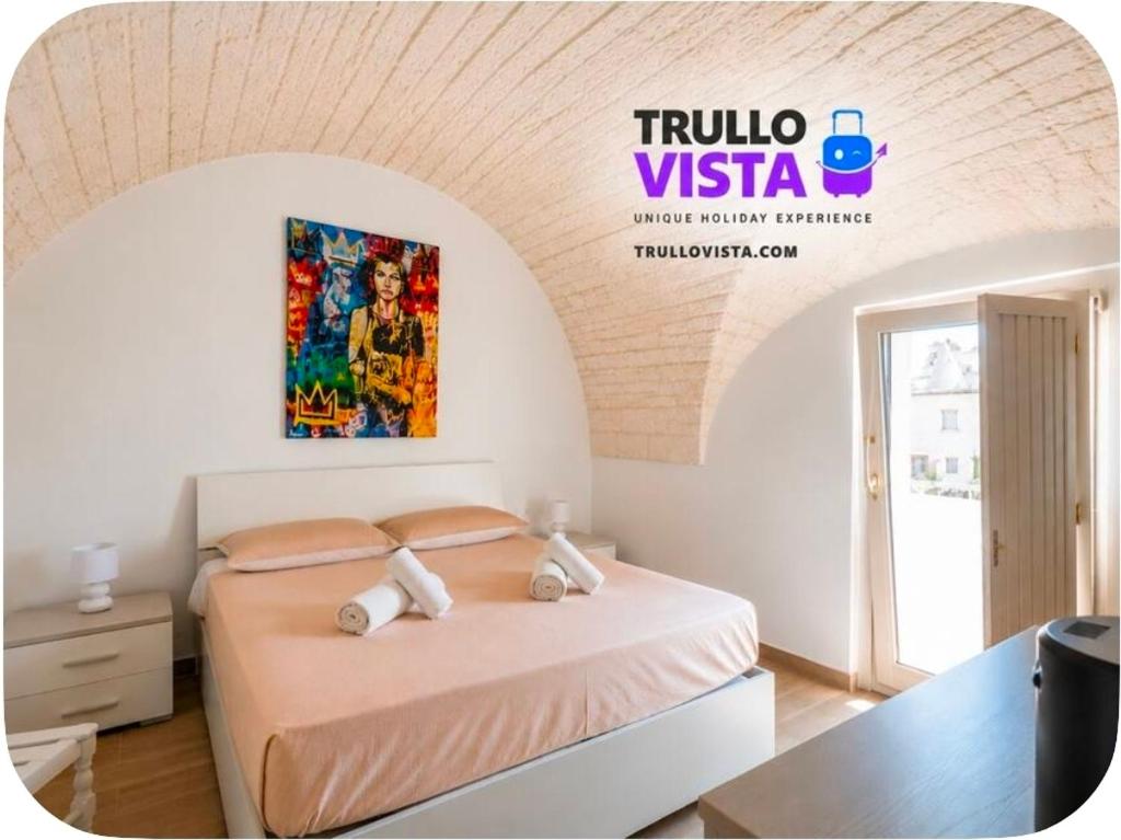 a bedroom with a bed with a painting on the wall at Rooftop Maisonette - Old Town by TrulloVista in Martina Franca