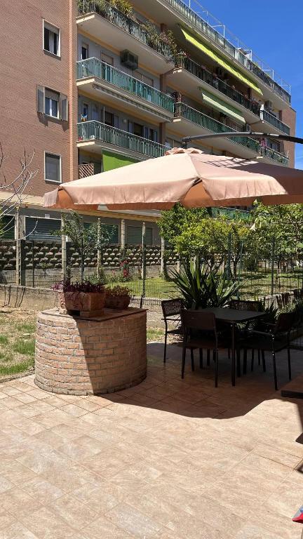 a patio with a table and umbrella in front of a building at Bilocale a 300m dal mare e 100m fermata filobus in Pescara