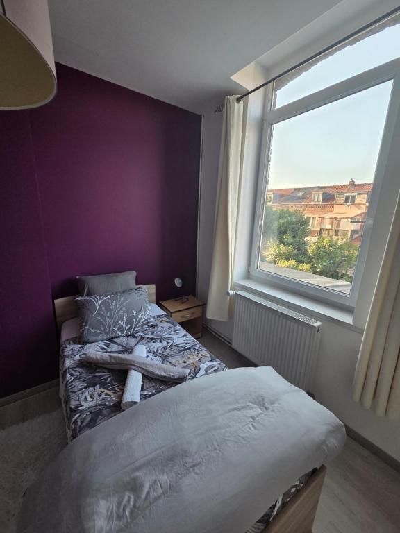a bedroom with a bed and a window at MAISON LA SOURCE d'hôte à Roubaix in Roubaix