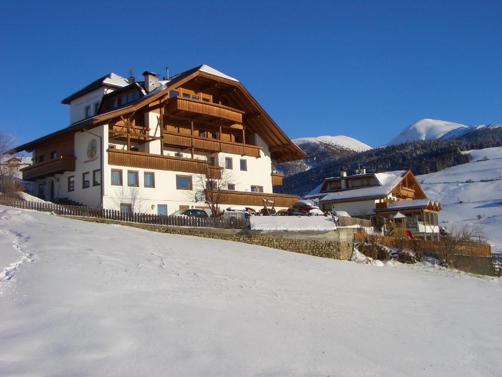 una casa grande en la nieve con una valla en Pension Schifferegger, en Maranza