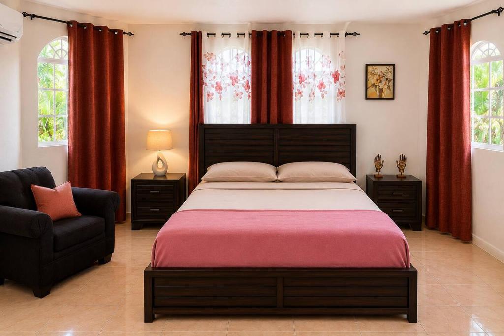 a bedroom with a large bed and a chair at The Hideaway Suite, largest master, ocean glimpse in Florence Hall