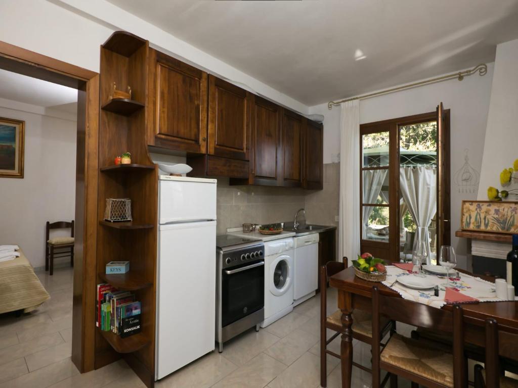a kitchen with a white refrigerator and a table at Huge Holiday Home in Marina di Castagneto Carducci near Sea in Donoratico