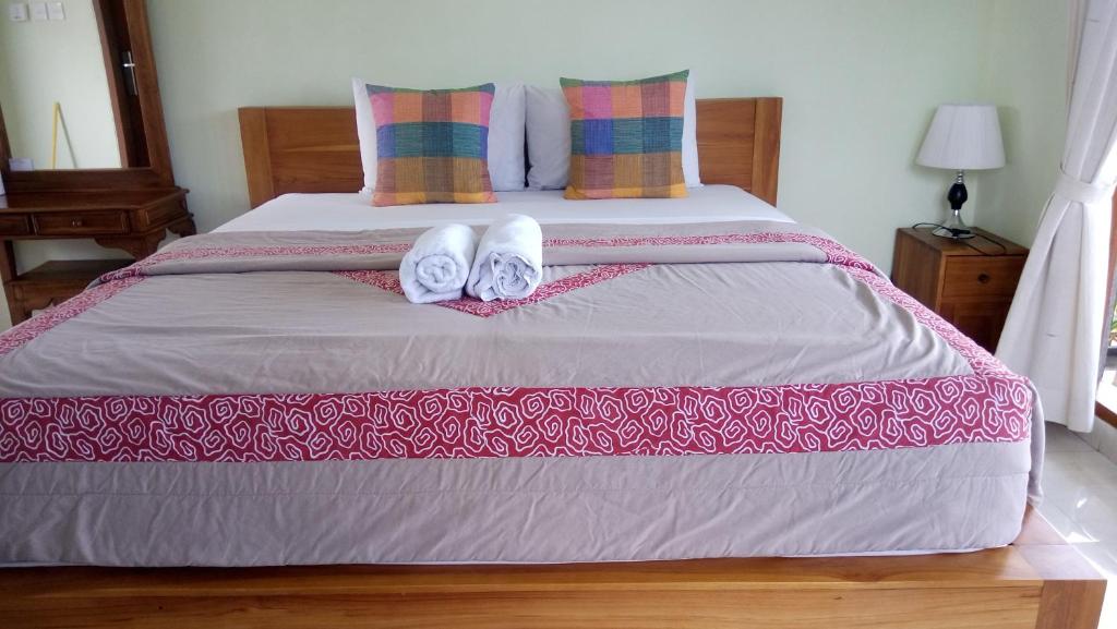 a bedroom with a bed with two towels on it at Sudiana House in Ubud