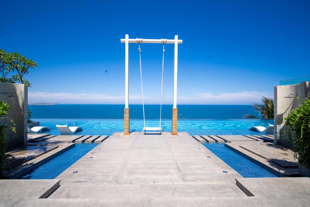 a cross on top of a pool with the ocean at Mandala Twilight Haven 5 Star in Phan Thiet