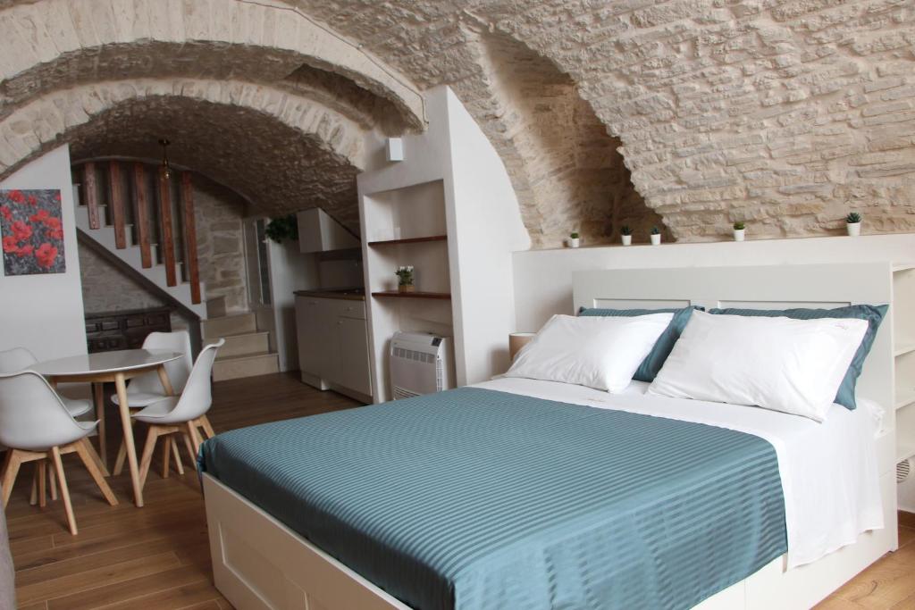 a bedroom with a bed and a table and chairs at Suites Anita in Ruvo di Puglia
