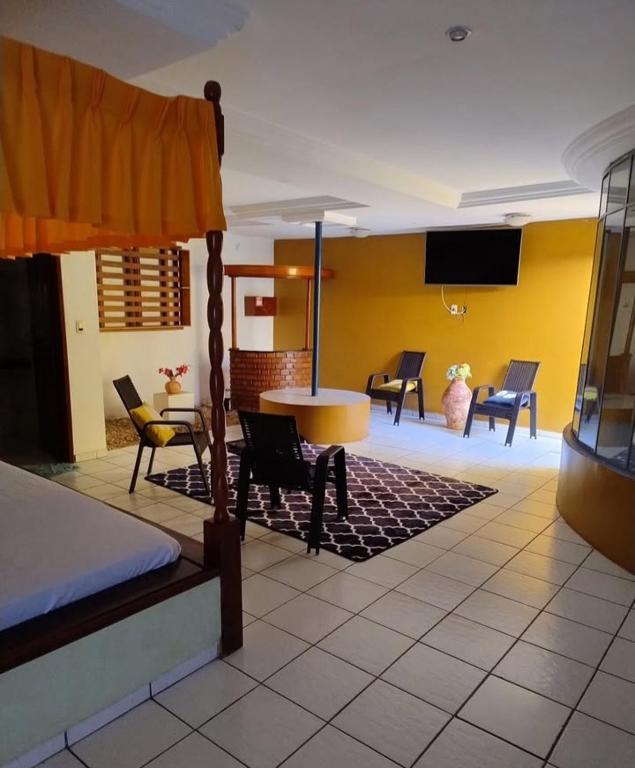 a bedroom with a bed and a table and chairs at Vamos lá in Caxias das Aldeias Altas