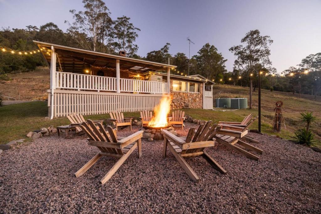 a fire pit in front of a house at Bellbird Rise Off-Grid Cottage in Conondale