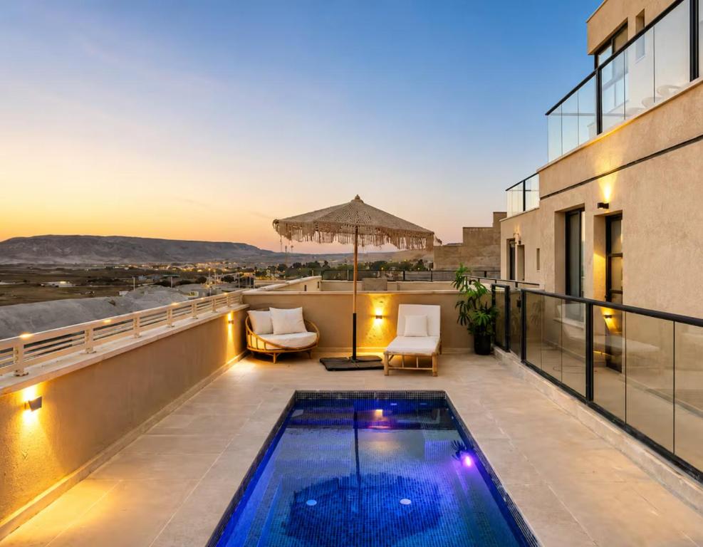 a balcony with a swimming pool on top of a building at ריזורט האחוזה- וילה עם בריכה פרטית וסוויטות עם בריכה משותפת מול נוף ים המלח in Neve Zohar