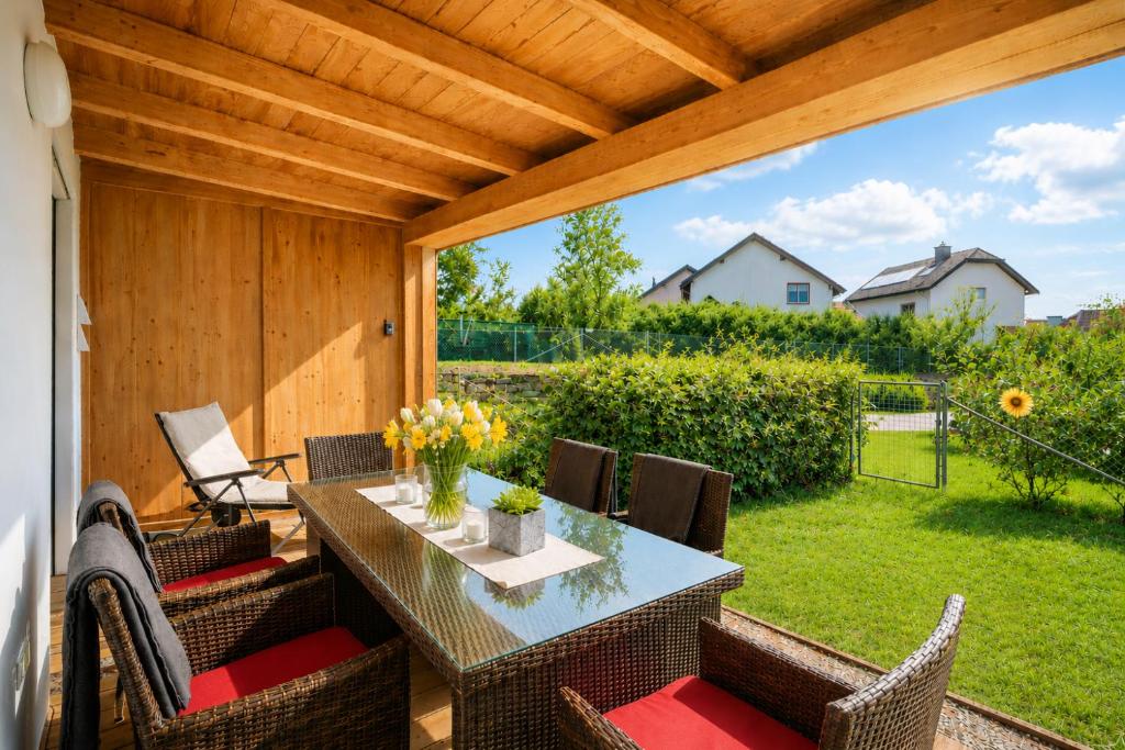 a patio with a table and chairs and a large window at Alpinum Residence Lungau Ferienwohnung mit Garten in Tamsweg