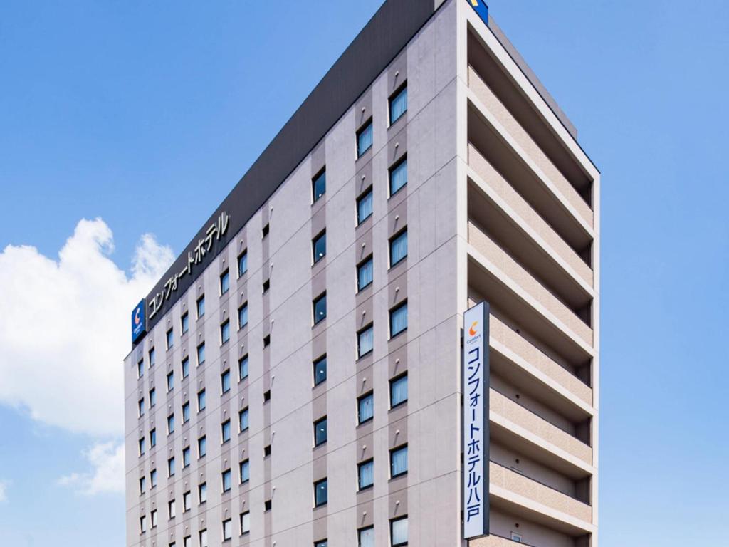 a building with a sign on the side of it at Comfort Hotel Hachinohe in Hachinohe