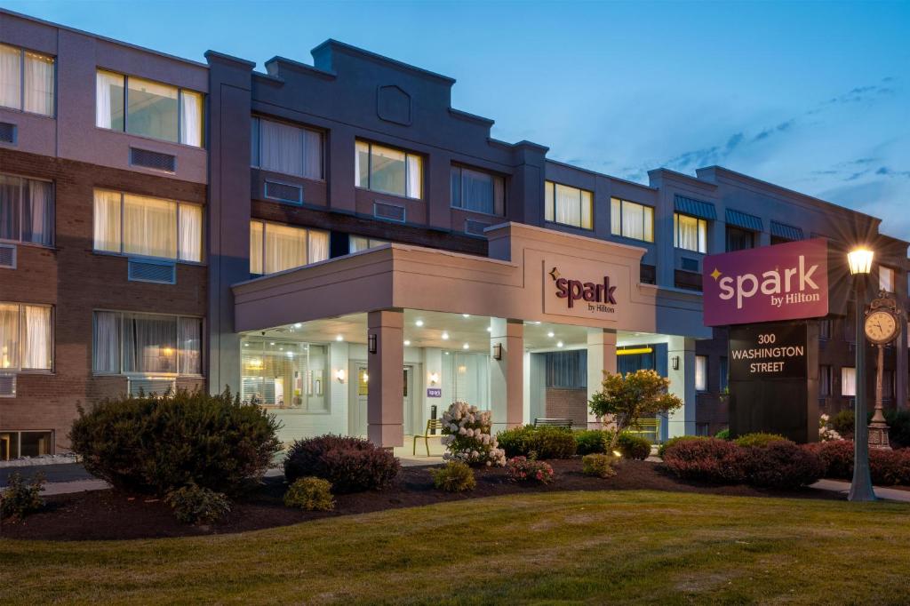 a building with a clock in front of it at Spark by Hilton Watertown, NY in Watertown