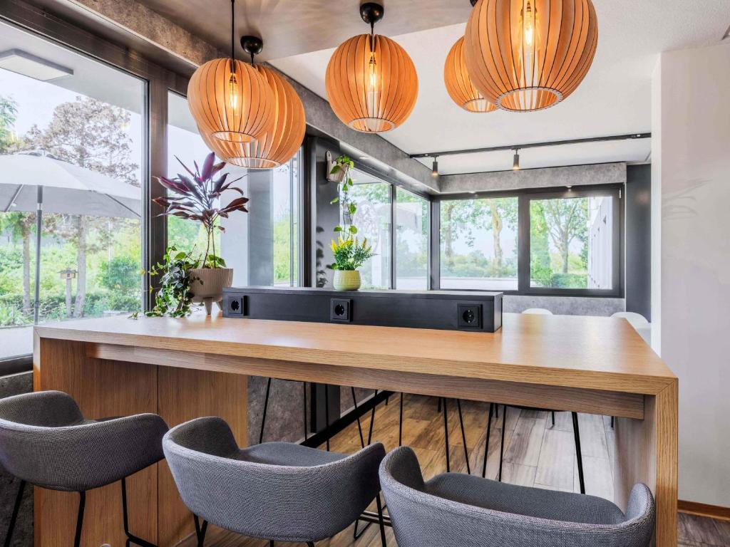 a dining room with a wooden table and chairs at B&B HOTEL Regensburg-Ost in Regensburg