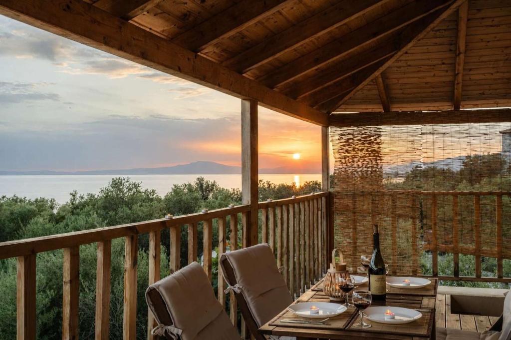 a patio with a table and chairs on a deck at Selinitsa Stone Studio - Mani Seaview Retreat in Agios Nikolaos