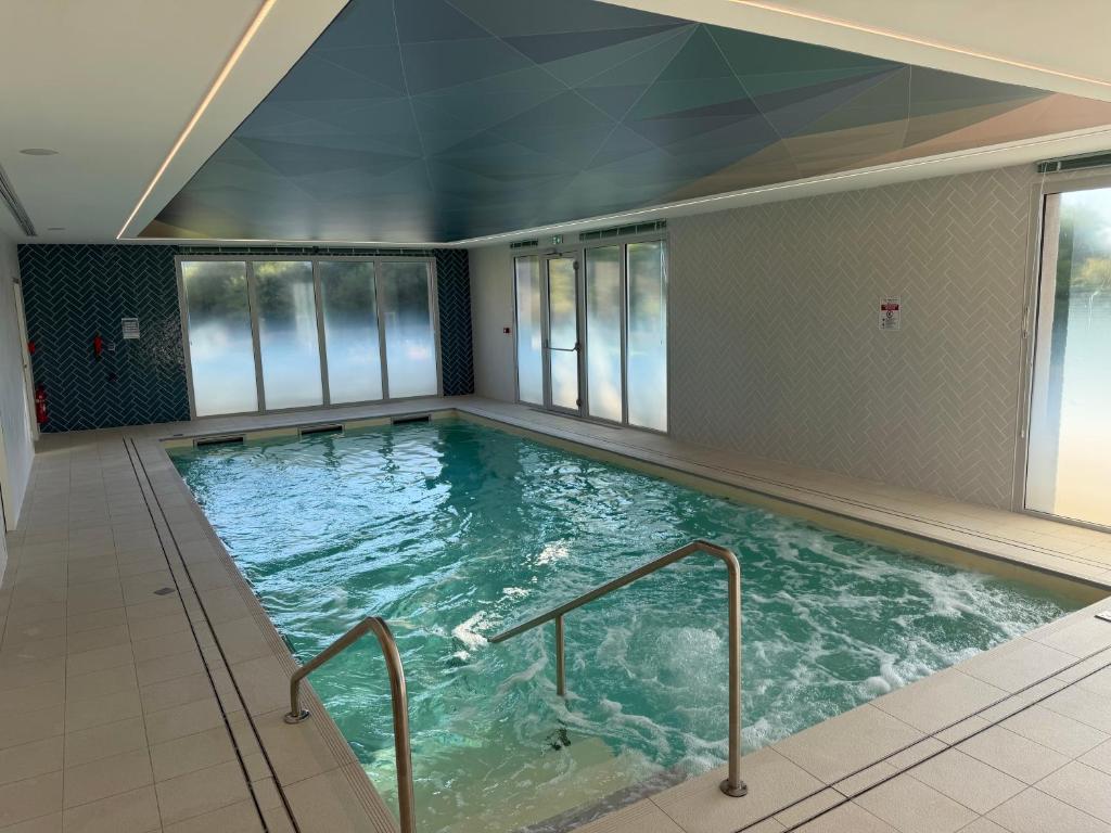 a large indoor swimming pool with glass windows at DOMITYS - Les Cerfs-Volants in Berck-sur-Mer