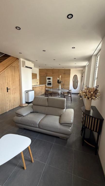 a living room with a couch and a table at Maison cosy climatisée in Bar-le-Duc