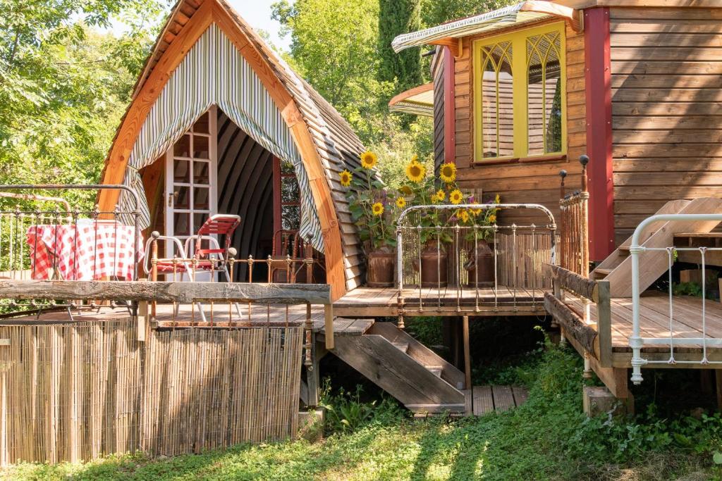 a log cabin with a porch and a deck at Les roulottes de Rita "Le poulailler" in Verfeil-sur-Seye