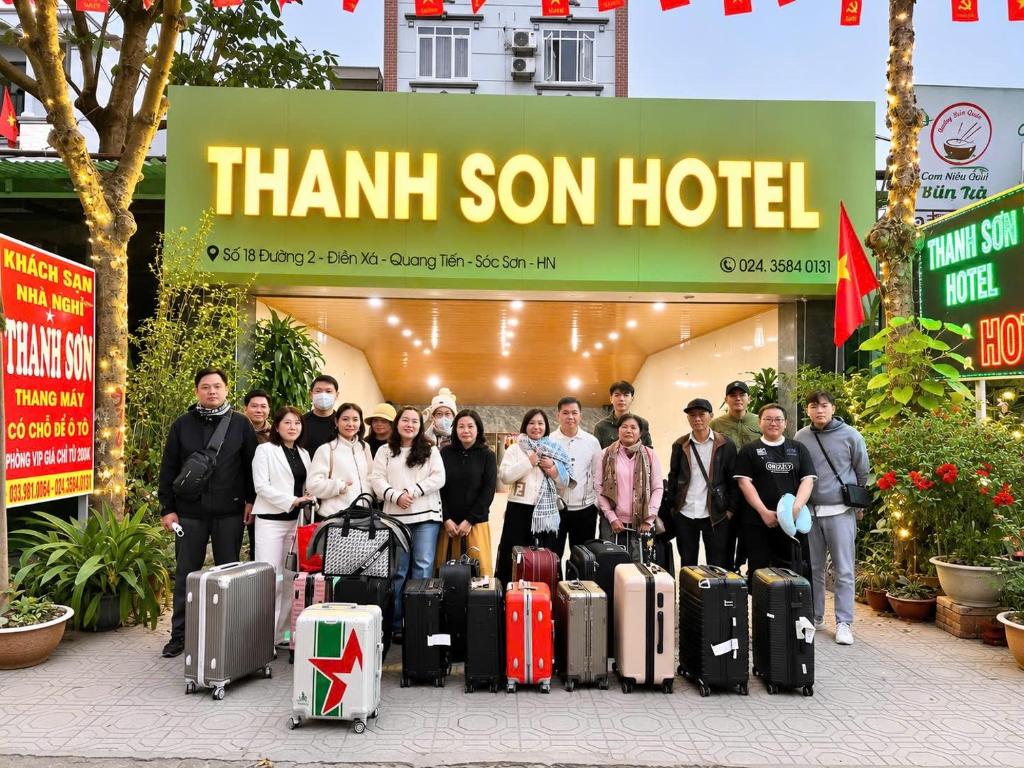 a group of people standing in front of a store with luggage at Khách sạn Thanh Sơn Nội Bài in Thach Loi