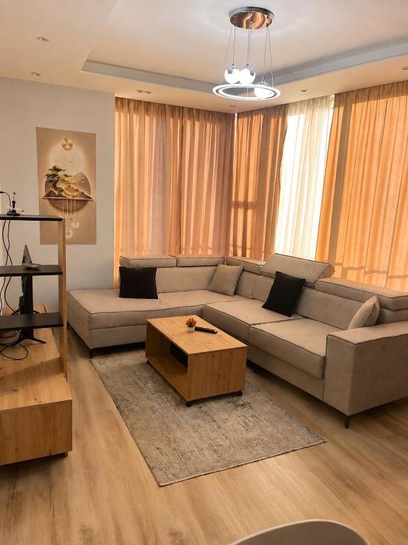 a living room with a couch and a coffee table at Cozy Apartment Astiri in Tirana