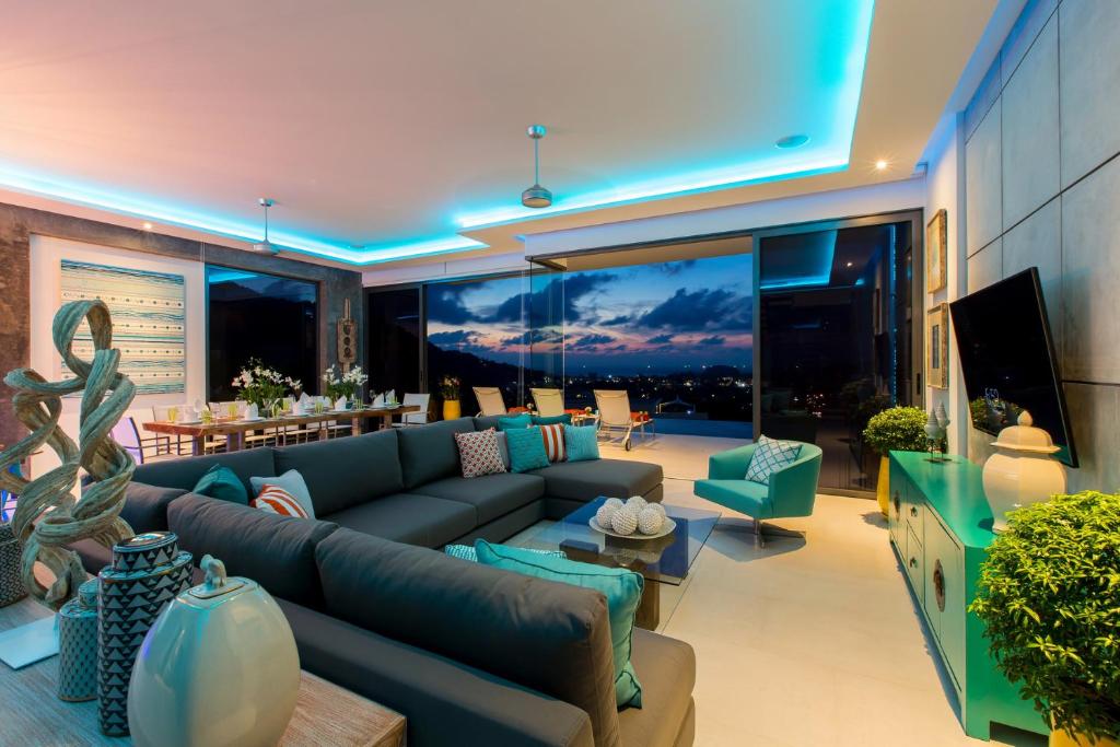 a living room with a couch and a tv at Villa Omari Seaview Pool & Game Room Kata in Kata Beach