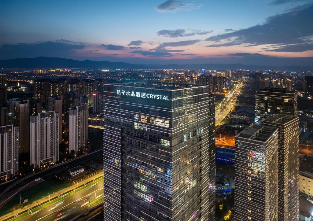 a view of a city skyline at night at Orange Crystal Hotel Kunming Haile World in Kunming