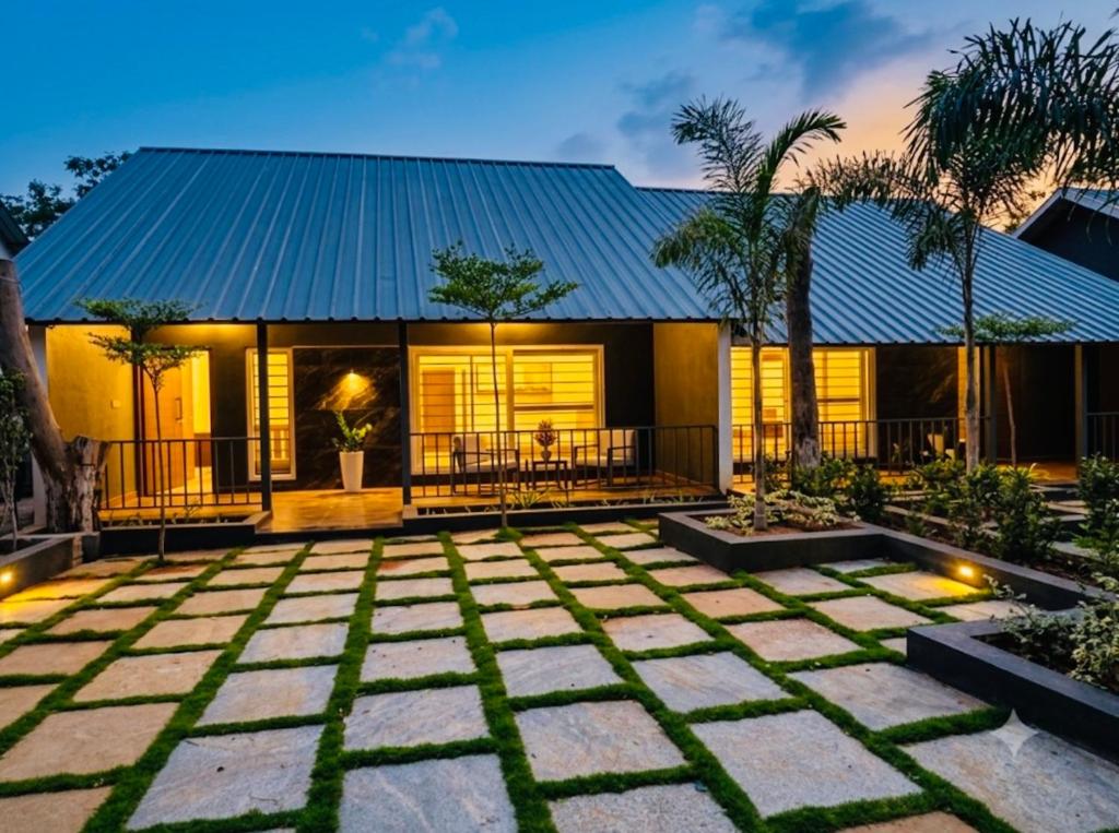 a house with a blue roof and a patio at 1000 SILVERS -Farm Stay in Mysore